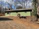 Exterior view of a home with green siding, a compact yard, and a gravel driveway at 420 Lee Dr, Acworth, GA 30102