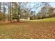 Expansive backyard featuring a large lawn area, mature trees, and a home in the distance at 504 Leguin Mill Rd, Locust Grove, GA 30248