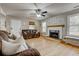 Cozy living room featuring a fireplace, hardwood floors, comfortable seating, and ample natural light from surrounding windows at 504 Leguin Mill Rd, Locust Grove, GA 30248