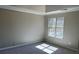 This bedroom has a large window, fresh gray paint, carpet and a tray ceiling at 6910 Stone Breeze Dr, Stone Mountain, GA 30087