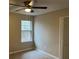 Bedroom features a window, neutral colored walls, white trim, and a ceiling fan for modern comfort and appeal at 6910 Stone Breeze Dr, Stone Mountain, GA 30087