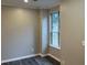 Neutral-toned bedroom with a large window providing natural light and gray wood-look floors throughout at 6910 Stone Breeze Dr, Stone Mountain, GA 30087