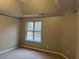 Bedroom showcasing a tray ceiling, neutral paint, plush carpet, and a window view at 6910 Stone Breeze Dr, Stone Mountain, GA 30087