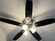 A close-up view of a ceiling fan featuring five dark blades and multiple lights, adding style and function at 6910 Stone Breeze Dr, Stone Mountain, GA 30087