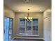 Bright dining area with chandelier, multiple windows, and sliding glass door, creating a warm and inviting atmosphere at 6910 Stone Breeze Dr, Stone Mountain, GA 30087