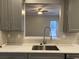 View from kitchen into living room with stainless sink and modern faucet at 6910 Stone Breeze Dr, Stone Mountain, GA 30087