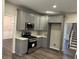 Open kitchen featuring gray cabinetry, stainless steel appliances, and a view to the home's interior at 6910 Stone Breeze Dr, Stone Mountain, GA 30087