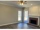 Spacious living room with a brick fireplace, large windows, a ceiling fan and hard surface floors at 6910 Stone Breeze Dr, Stone Mountain, GA 30087