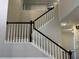 Open staircase with black handrail and white spindles, adding a modern and elegant touch to the home's design at 6910 Stone Breeze Dr, Stone Mountain, GA 30087