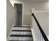 A set of black and white stairs in a home, viewed from the bottom, leading to an open doorway at 6910 Stone Breeze Dr, Stone Mountain, GA 30087