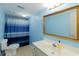 Modern blue bathroom with tile floor, vanity sink and a framed mirror at 814 Oak Moss Dr, Lawrenceville, GA 30043