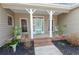 Close up of a warm and inviting front porch area with seating and decorative plants at 814 Oak Moss Dr, Lawrenceville, GA 30043