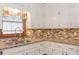 Kitchen details with granite countertops, white cabinets, and tiled backsplash at 814 Oak Moss Dr, Lawrenceville, GA 30043