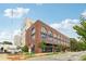 Brick building featuring arched windows with modern facade, complete with streetscape and parking area view at 112 Rogers Ne St # 206, Atlanta, GA 30317