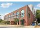 Exterior view of a brick building featuring arched windows and modern signage, capturing the building's facade at 112 Rogers Ne St # 206, Atlanta, GA 30317