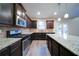 A well-equipped kitchen featuring stainless steel appliances, dark wood cabinets, granite countertops, and a central island at 4280 Hunters Walk Way, Cumming, GA 30028