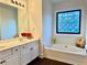 Bathroom featuring a double vanity sink, soaker tub, and decorative window at 2586 Abbotts Glen Dr, Acworth, GA 30101