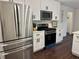 Modern kitchen featuring stainless steel appliances, white cabinets, and dark wood flooring at 2586 Abbotts Glen Dr, Acworth, GA 30101