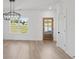 Bright dining space featuring wood floors, wainscotting, a modern chandelier, and a backyard view at 3555 New Hope Rd, Dacula, GA 30019