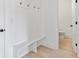 Mud room with coat hooks, built in bench, shoe storage and easy access to a half bath at 3555 New Hope Rd, Dacula, GA 30019