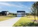 View of the home's facade, featuring a concrete driveway and landscaped front lawn at 3555 New Hope Rd, Dacula, GA 30019