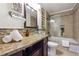 Well-lit bathroom with a granite vanity top, glass bowl sink, and tiled shower and bathtub at 1474 Athens Avenue Sw Ave, Atlanta, GA 30310