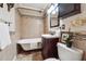This bathroom features a claw foot tub with updated tiling and a dark wood vanity at 1474 Athens Avenue Sw Ave, Atlanta, GA 30310