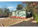 Rear exterior of the home with green siding, gravel walkway, and partially fenced-in yard at 1474 Athens Avenue Sw Ave, Atlanta, GA 30310