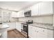 Contemporary kitchen with white cabinetry, stainless steel appliances, and granite countertops at 170 Charlotte Blvd, Stockbridge, GA 30281