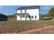 Wide backyard view featuring the home, covered porch, and an expansive lawn at 3563 New Hope Rd, Dacula, GA 30019