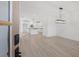 Open-concept dining area and kitchen with wood flooring, white cabinetry, and modern lighting fixtures at 3563 New Hope Rd, Dacula, GA 30019