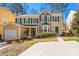 Inviting two-story home with stone accents, lush landscaping, and a spacious driveway at 1381 Vintage Pointe Dr, Lawrenceville, GA 30044