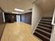 Finished basement features wood-look flooring, brick accent wall, and staircase at 32 Ne Moriah Way, Rydal, GA 30171