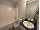 Well-lit bathroom features a shower-tub combo and single sink vanity with blue countertop at 32 Ne Moriah Way, Rydal, GA 30171