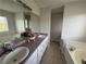 Bright bathroom with dual sinks, tile flooring, and a soaking tub at 32 Ne Moriah Way, Rydal, GA 30171