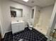 Bathroom with black tile floor features white vanity, mirror, and shower stall at 32 Ne Moriah Way, Rydal, GA 30171