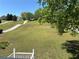 Expansive front yard with lush green grass and mature trees, leading to a charming home at 32 Ne Moriah Way, Rydal, GA 30171