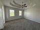 Large main bedroom with neutral carpet, tray ceiling, and double windows for ample light at 32 Ne Moriah Way, Rydal, GA 30171
