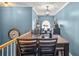 Cozy dining area featuring modern lighting, table and chairs, with a clock on the blue wall at 340 Lazy Willow Ln, Lawrenceville, GA 30044