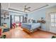 Main bedroom with a tray ceiling, bay windows, ceiling fan, hardwood floors, and a door to a deck at 340 Lazy Willow Ln, Lawrenceville, GA 30044