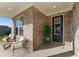 Inviting front porch with comfortable seating, potted plant, and brick accents, perfect for relaxing at 48 Masters Dr, Villa Rica, GA 30180