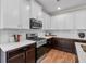 Well-equipped kitchen with stainless steel appliances, white cabinets, hardwood floors and dark countertops at 71 Colonial Terrace, Villa Rica, GA 30180