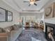 Cozy living room featuring a fireplace, ceiling fan, large windows, and comfortable seating at 71 Colonial Terrace, Villa Rica, GA 30180