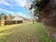 Expansive backyard featuring a well-maintained lawn, mature trees, and a privacy fence at 125 Whistle Way, Locust Grove, GA 30248