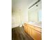 Bathroom with a large mirror, laminate floors, and a shower-tub combo at 125 Whistle Way, Locust Grove, GA 30248
