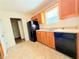 Bright kitchen area with tile floor, stainless steel sink, wooden cabinetry, and view of door to other rooms at 125 Whistle Way, Locust Grove, GA 30248