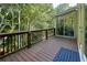 Spacious back deck with wood railing, wooded view and sliding glass door to sunroom at 190 Winford Close, Duluth, GA 30097