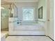 Elegant bathroom features a soaking tub, shower with glass door, and unique stained glass window at 190 Winford Close, Duluth, GA 30097