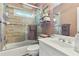 Bathroom featuring a tiled shower-tub, toilet, sink, a shelf, and pink paint at 190 Winford Close, Duluth, GA 30097