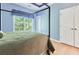 Bright bedroom featuring a four-poster bed, hardwood floors and an ensuite bathroom at 190 Winford Close, Duluth, GA 30097